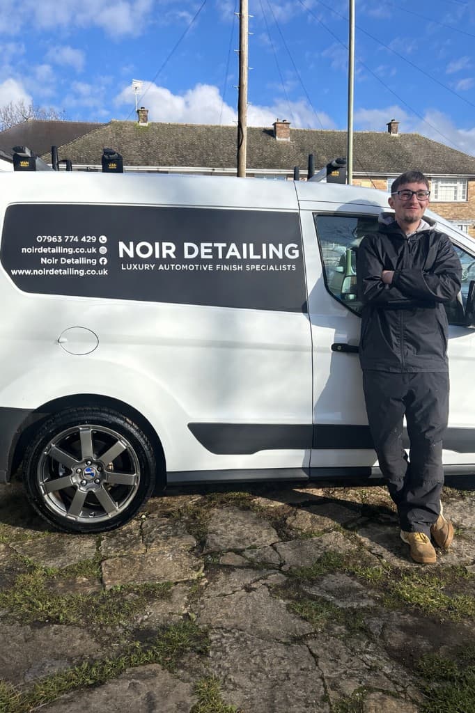 Liam, founder of Noir Detailing, beside the Noir Detailing van