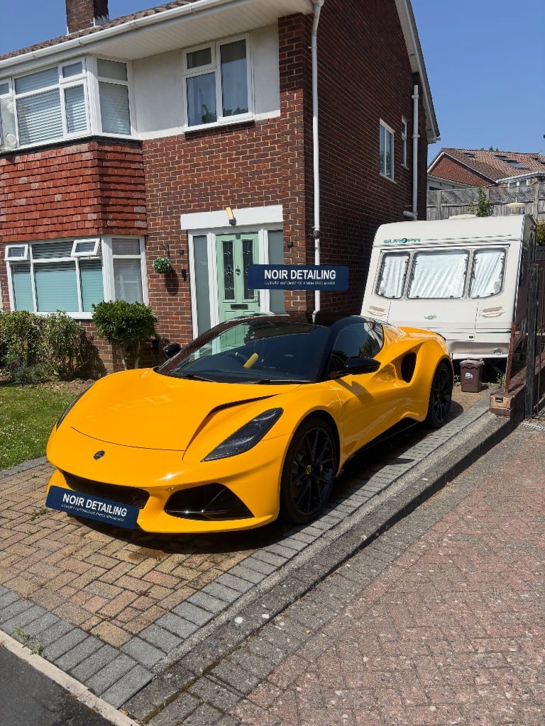 Yellow Lotus Emira freshly detailed on a driveway with Noir Detailing boards