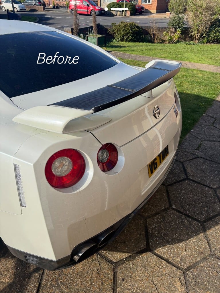 White Nissan GT-R rear with dull, watermarked paint before polishing
