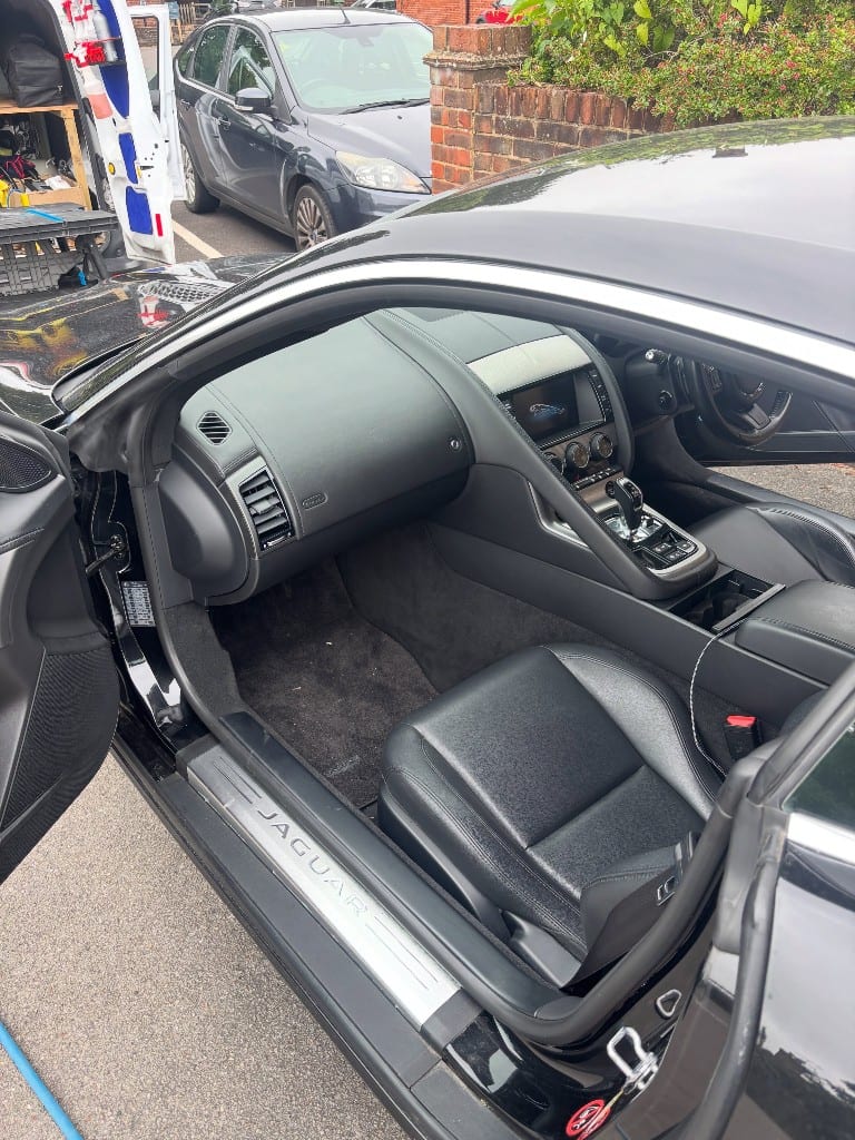 Jaguar F-Type footwell and carpet dusty and dirty before an interior detail