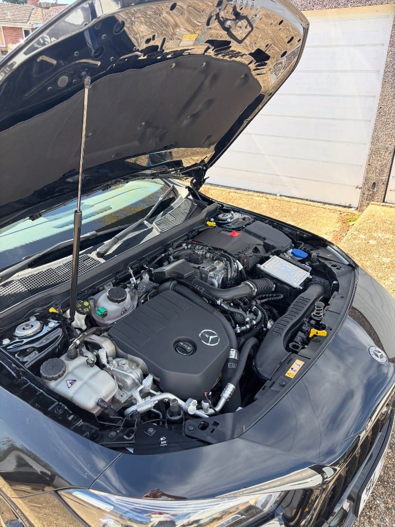 The same Mercedes engine bay cleaned and dressed to a factory-fresh finish
