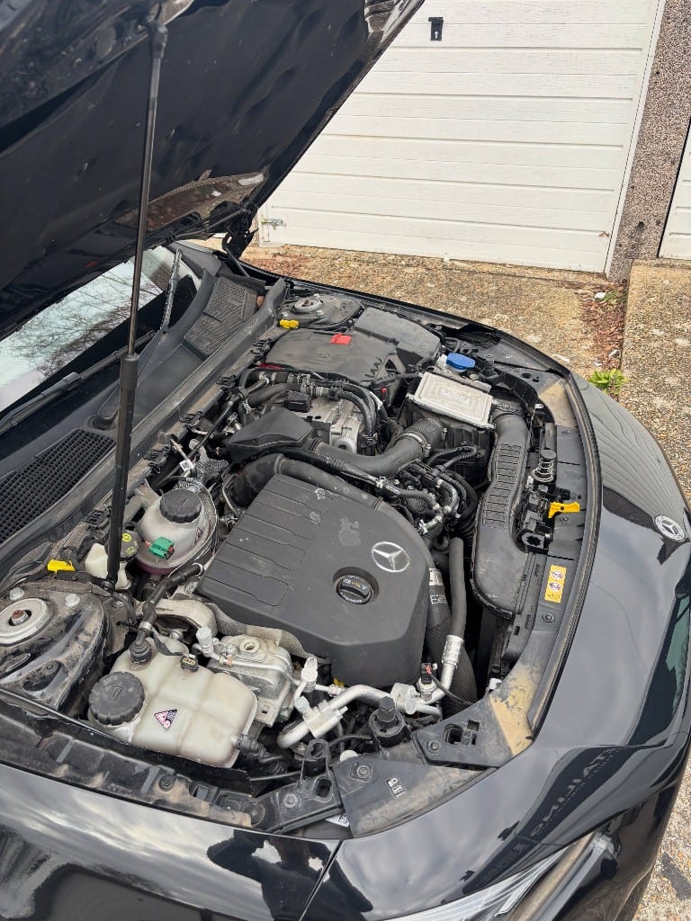 Mercedes engine bay with road grime and dust before an engine bay detail